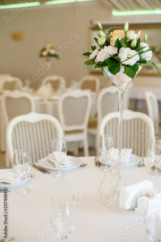 The round table is covered with a white tablecloth © bartoshd