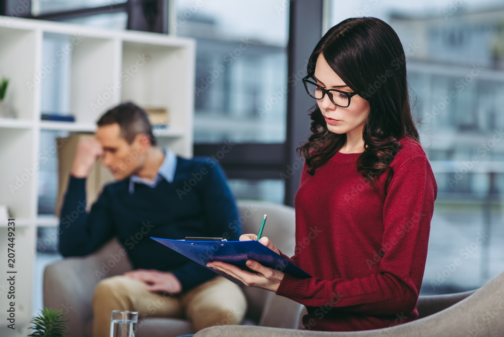 psychologist making notes in document psychologist making notes in document