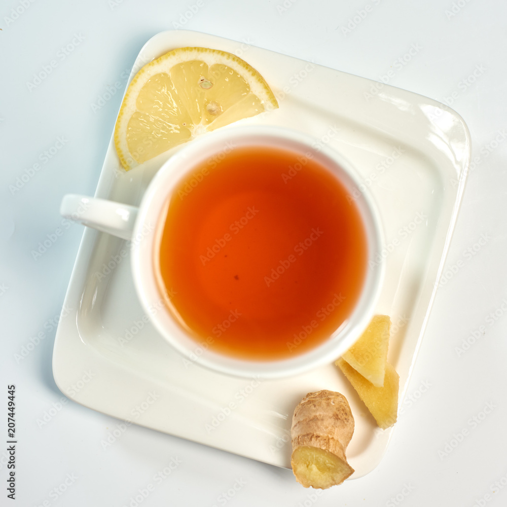 Tea with lemon and ginger./Tea in a white cup with lemon and ginger. Isolated on white background.
