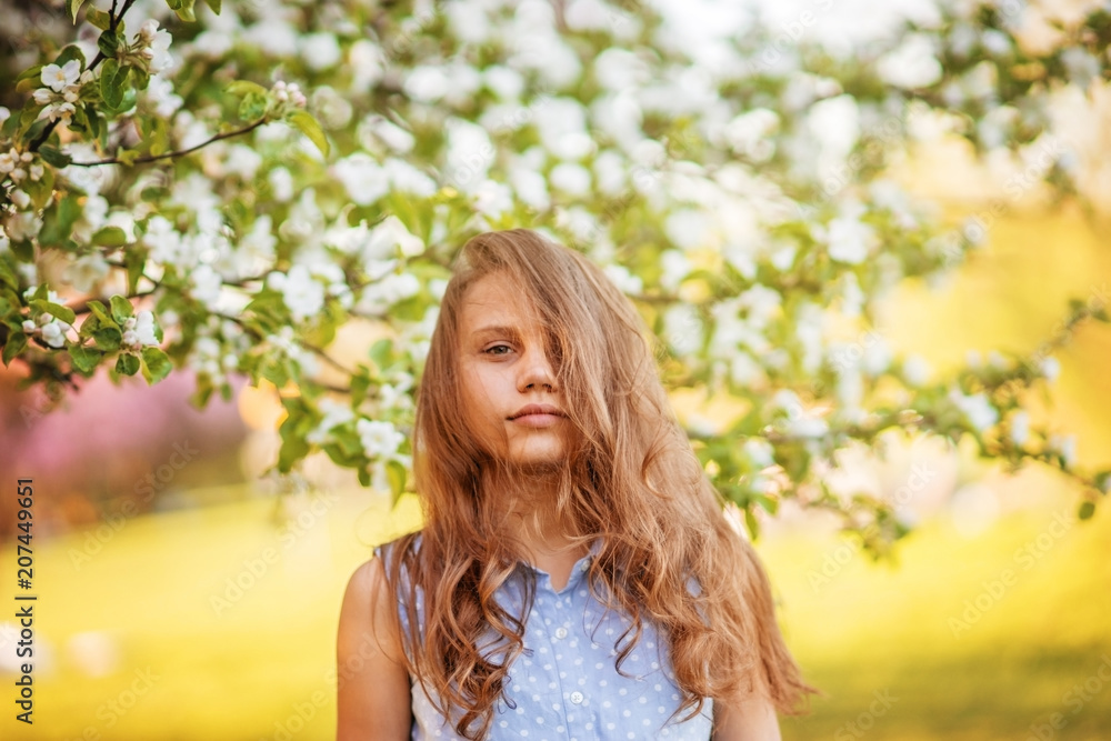 Portrait of a beautiful smiling girl with beautiful long hair in spring garden. Portrait of a beautiful smiling girl with beautiful long hair in spring garden.