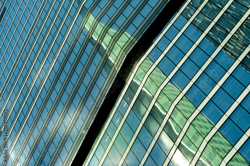 reflection of a tower of a skyscraper in a glass building of another skyscraper