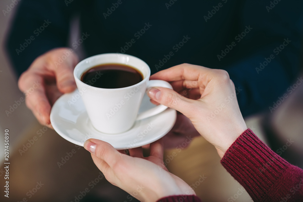 man giving woman cup of coffee man giving woman cup of coffee