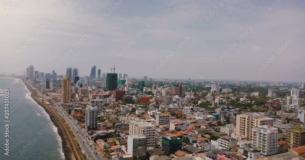 Drone panning right over beautiful coastline, modern buildings of Colombo, Sri Lanka. Aerial view of Asian cityscape. Drone panning right over beautiful coastline, modern buildings of Colombo, Sri Lanka. Aerial view of Asian cityscape.