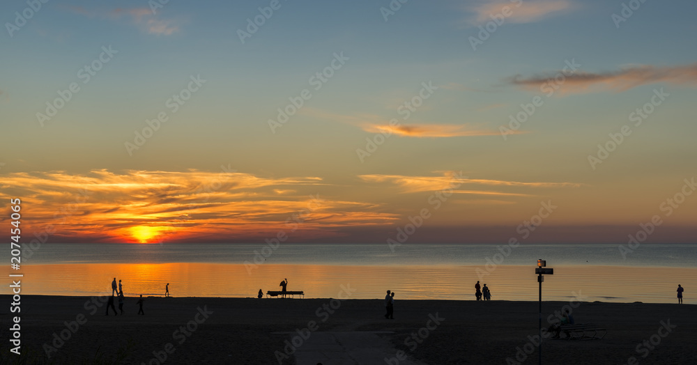 Summer sunset at sandy beach of Jurmala - famous Baltic resort in Latvia, Europe. Summer vacation concept Summer sunset at sandy beach of Jurmala - famous Baltic resort in Latvia, Europe. Summer vacation concept