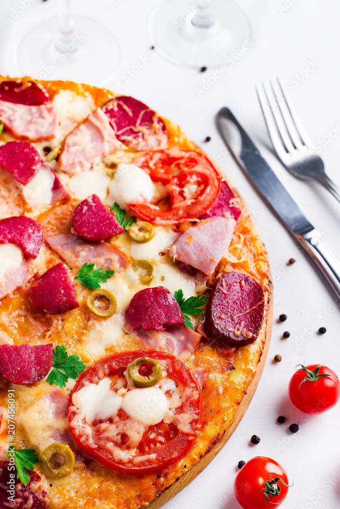 Hot pizza with Pepperoni Sausage on a white table Hot pizza with Pepperoni Sausage on a white table