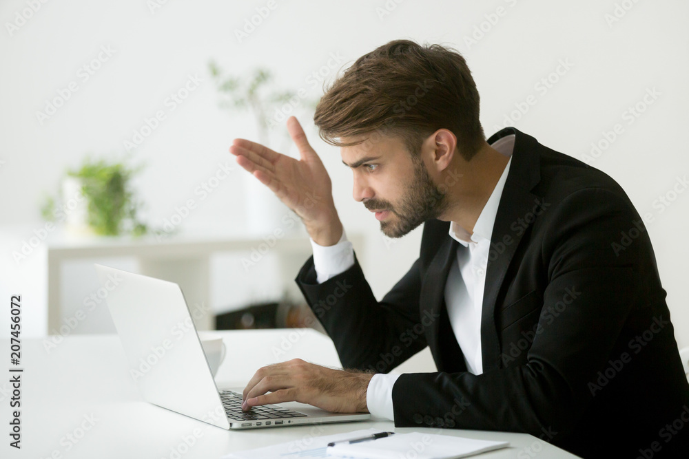 Frustrated worried businessman disappointed by negative online business news, shocked with falling sales, dissatisfied with company market failure, financial crisis, PC error. Concept of work stress Frustrated worried businessman disappointed by negative online business news, shocked with falling sales, dissatisfied with company market failure, financial crisis, PC error. Concept of work stress