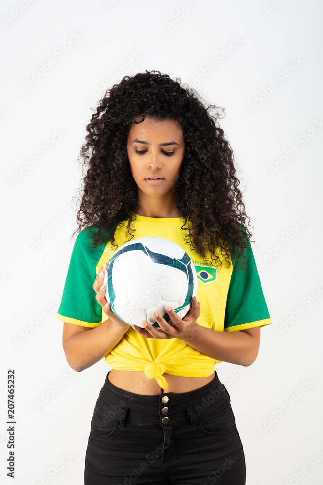 Portrait d'une jeune supportrice de l'équipe du Brésil regardant un ballon Portrait d'une jeune supportrice de l'équipe du Brésil regardant un ballon