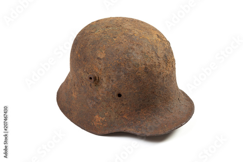 Vintage M1916 German Imperial Army steel helmet, or stahlhelm, used in World War I in rusty condition, isolated on white photo