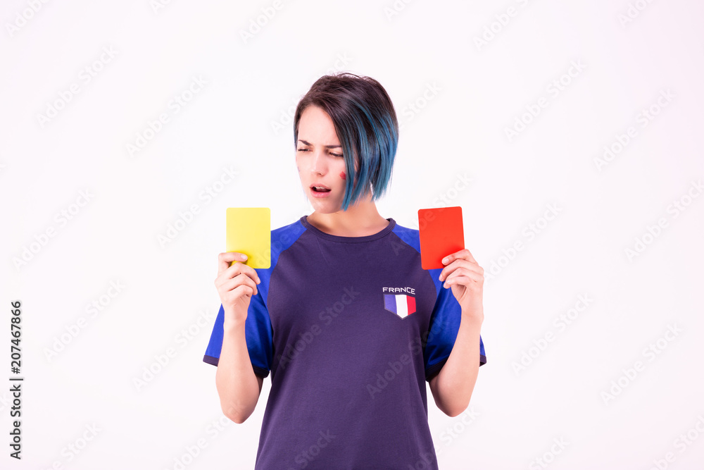 Portrait d'une jeune supportrice de l'équipe de France de football face à un carton jaune et rouge Portrait d'une jeune supportrice de l'équipe de France de football face à un carton jaune et rouge