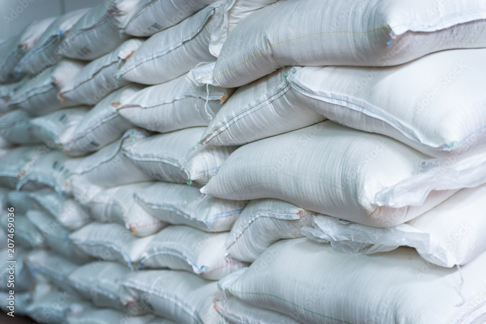 Obraz premium Stack of sugar or flour bags in warehouse