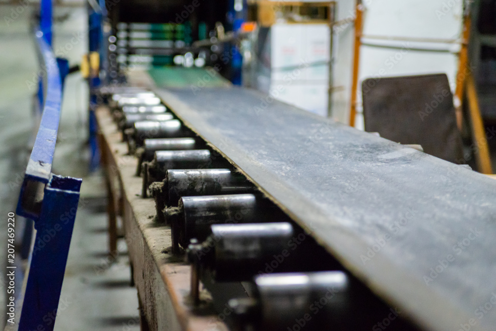 Industrial belt conveyor moving raw materials on factory