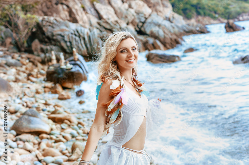 beautiful young boho style woman in white dress on stone beach beautiful young boho style woman in white dress on stone beach