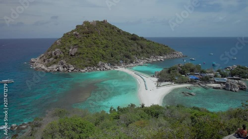 Beach with arriving tourist and sunbed on Koh Nangyuan Island on bright sunny day surraunded by beautiful crystal clear blue water, Surat Thani, Thailand photo