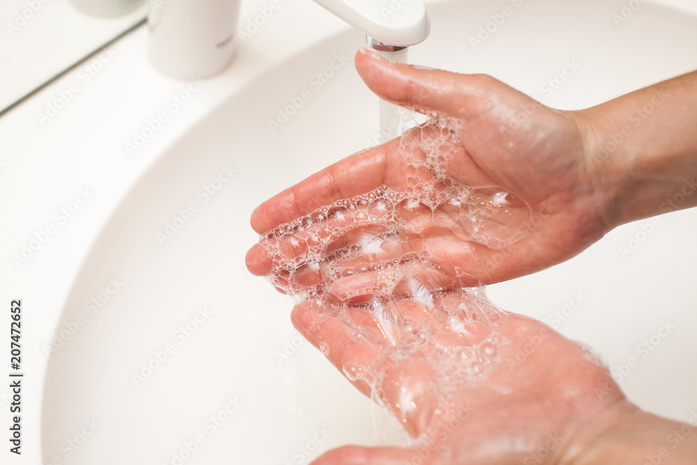Fototapeta premium close up photo of woman washes her hands with soap and water