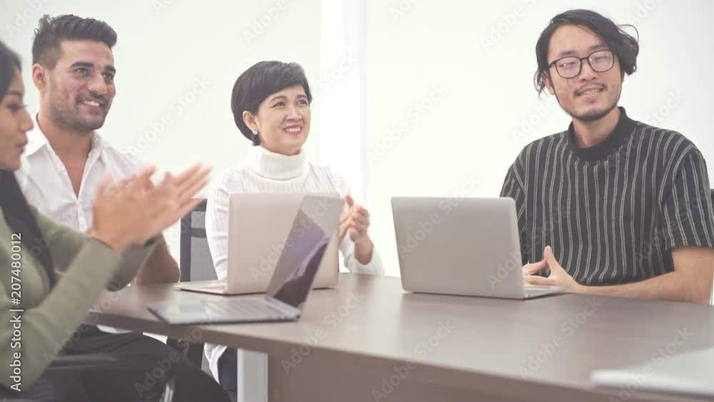 Business meeting. Small start up business meeting in room. Asian team with indian man brainstorming the next big idea, clapping. New business model start up concepts. Business meeting. Small start up business meeting in room. Asian team with indian man brainstorming the next big idea, clapping. New business model start up concepts.
