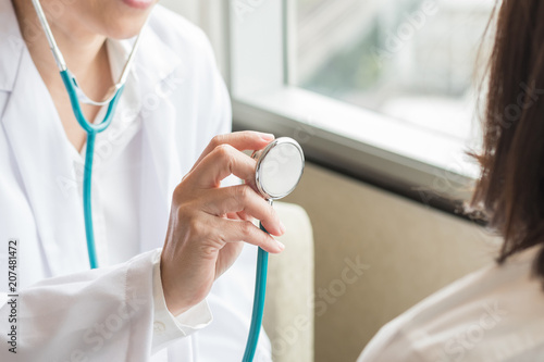 Doctor examining woman patient s health check using stethoscope in medical clinic