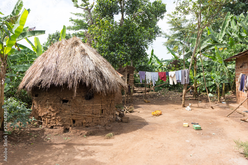 Buikwe, Uganda. 9 May 2017. A mud-and-daub roundhouse with thatched roof. A laundry line next to it.