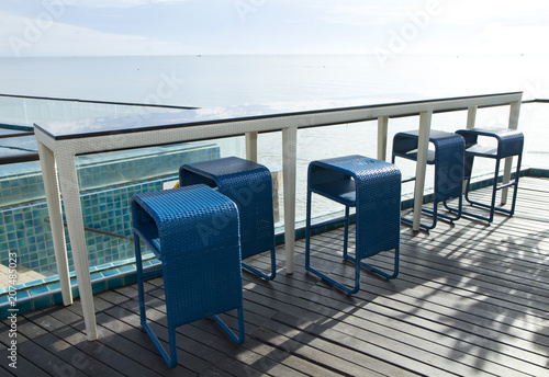 Row of blue weave bar stools with sea view in hotel or restaurant