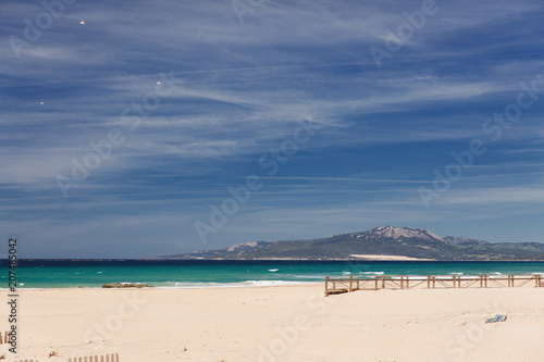 White clouds with a blue sky over a calm ocean beach in the Spanish city of Tarifa