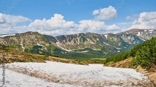 Panorama of Carpathian mountains in the summer with green hills and snow. Mountains landscape background. Nature beauty