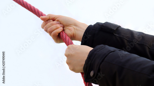 Φωτογραφία A hand holding a red rope
