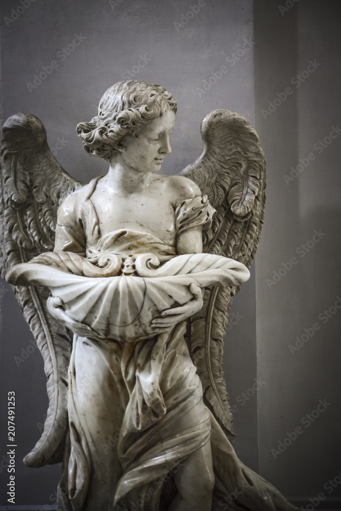 Angel. Baptismal font inside the church of St. Mary of the Angels and Martyrs, Rome, Italy