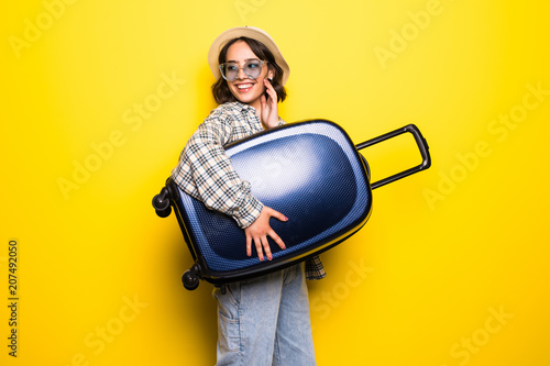 Young trend Woman in sunglasses and straw hat ready for summer travel isolated on yellow background