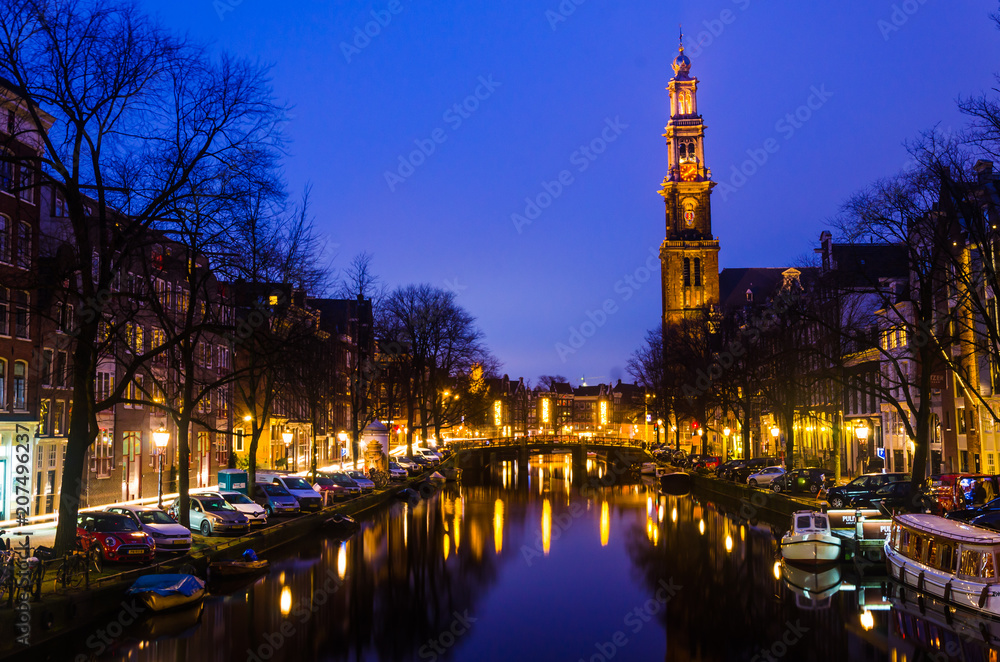  Sunrise on a canal with old historical church on the horizon in Amsterdam water Holland bridge for summer holiday vacation family couple and friends