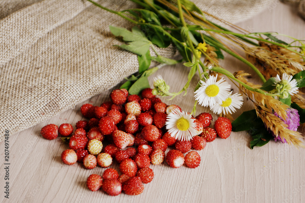 wild strawberries and flowers on the table wild strawberries and flowers on the table