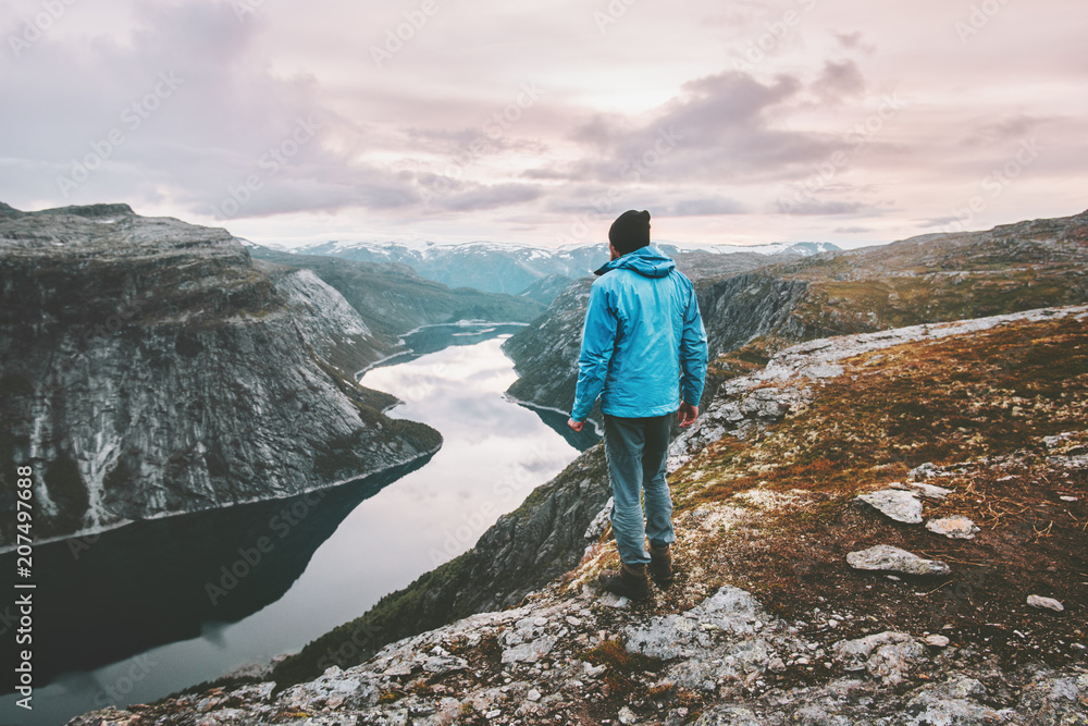 Obraz premium Hiker man traveling alone walking in sunset mountains landscape adventure journey lifestyle vacations weekend getaway aerial Norway lake landscape