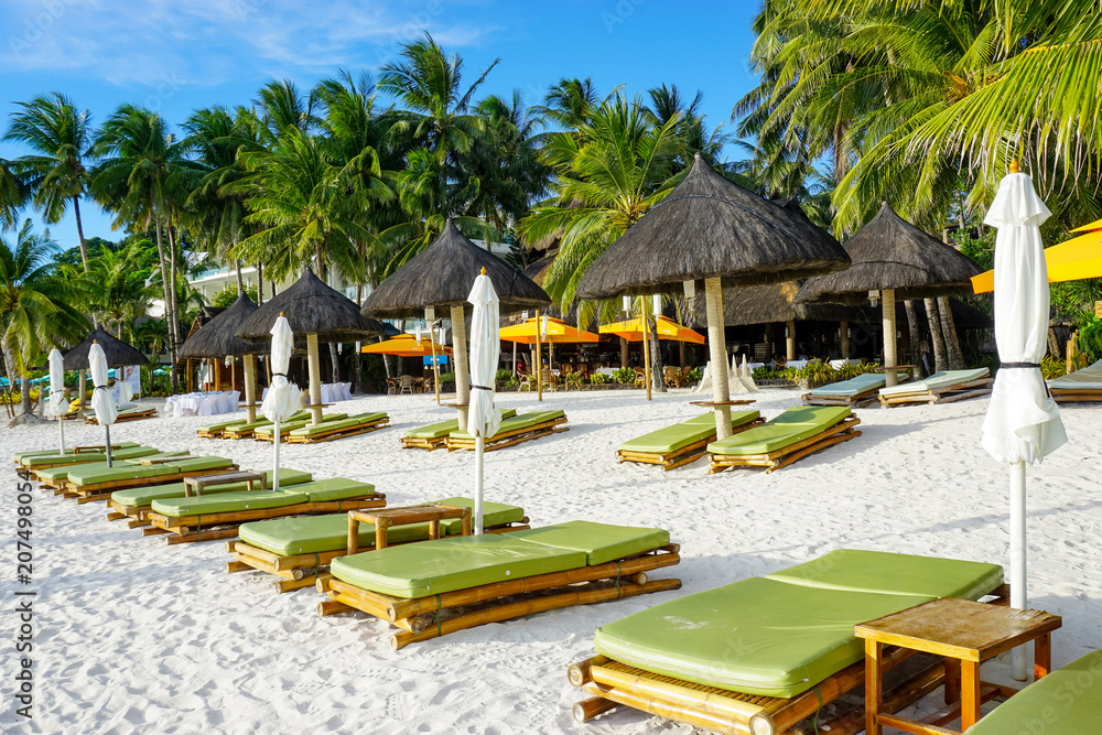 White sand beach with palm trees and chaises longue with umbrellas, Boracay, Philippines