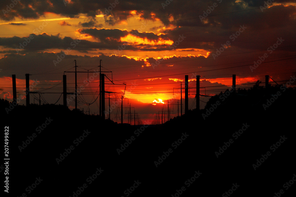 electricity path to the west/ silhouette of power lines against sunset and clouds