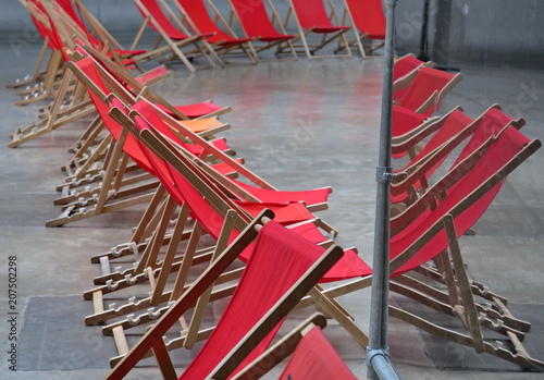 Chaises longues rouges et béton avec reflet