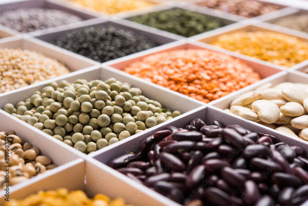 Indian Beans,Pulses,Lentils,Rice and Wheat grain in a white wooden box with cells, selective focus.