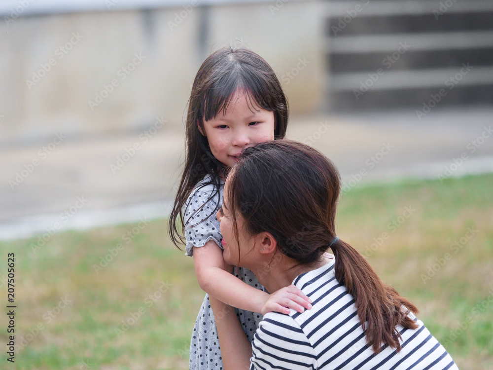 Close up happy little girl face in her mother arms. Close up happy little girl face in her mother arms.