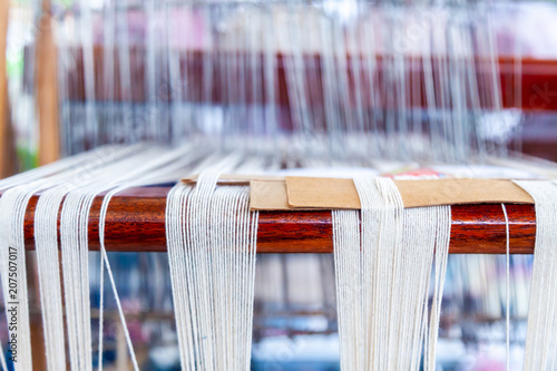 Close Up of White Linen on the Weaving machine and Thai traditional Linen. Weaving loom for homemade Linen textile