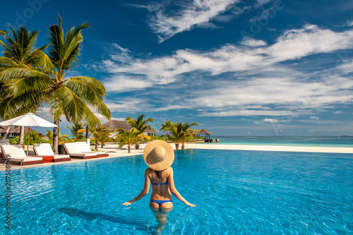Woman with hat at beach pool in Maldives