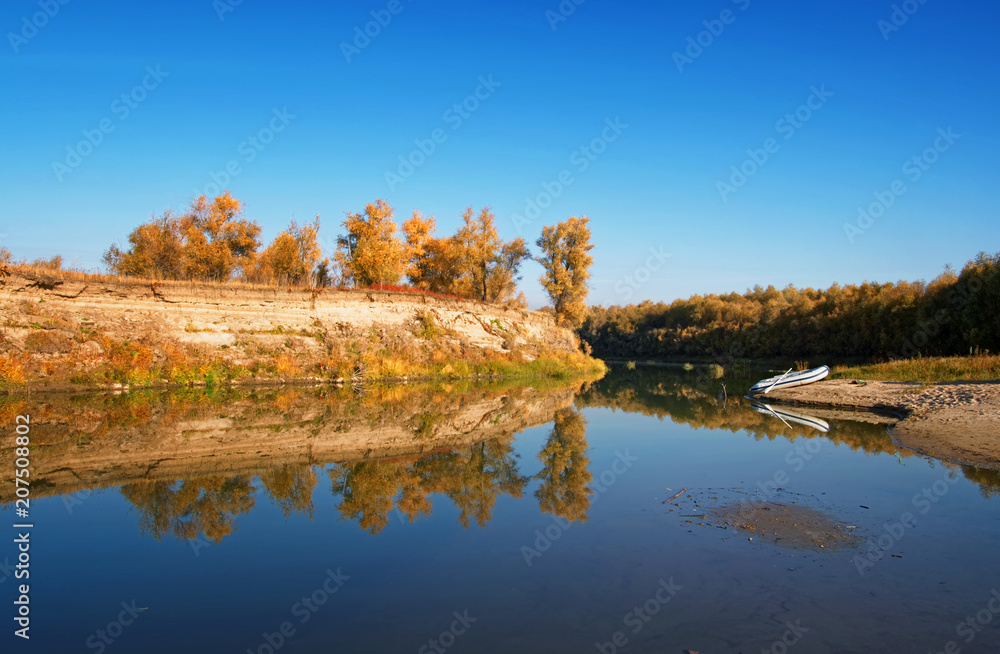Autumn Siberian landscape-a lonely inflatable boat moored on the river bank