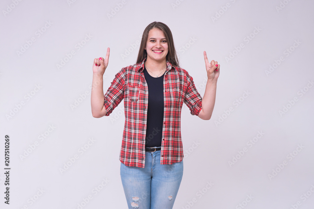 portrait of a beautiful brunette girl on a white background in jeans in different poses showing on the product. portrait of a beautiful brunette girl on a white background in jeans in different poses showing on the product.