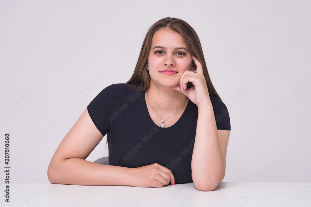 Portrait of a beautiful manager girl on white background at a table. Portrait of a beautiful manager girl on white background at a table.