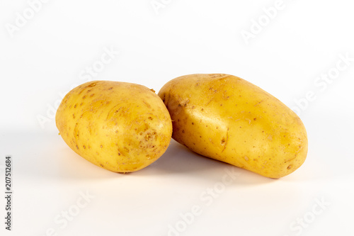 Two unpeeled fresh potatoes isolated on white background