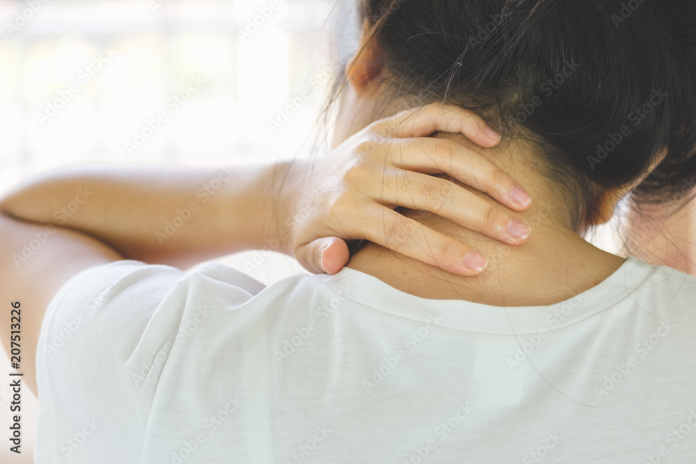 Closeup of young woman suffering from pain in neck while sitting on bed at home, People with body-muscles problem, Healthcare And Medicine concept Closeup of young woman suffering from pain in neck while sitting on bed at home, People with body-muscles problem, Healthcare And Medicine concept