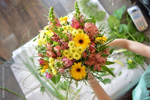 woman binds flower bouquet in florist photo