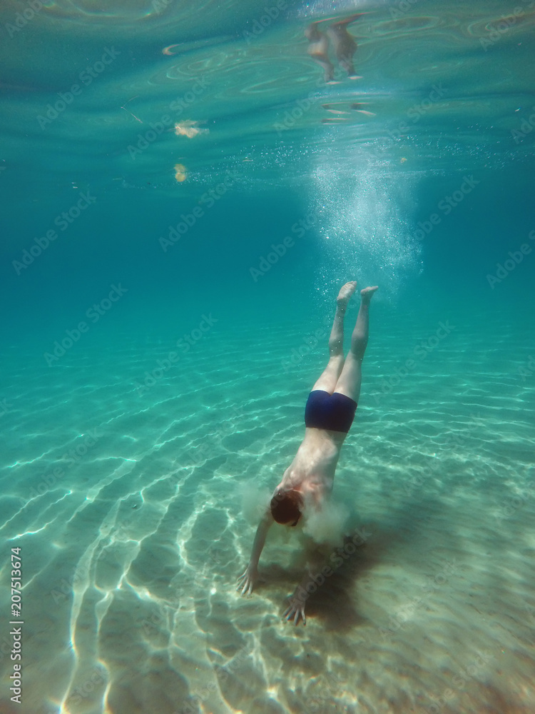 young man dives into the sea