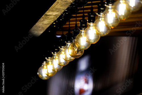 Tungsten circle lamp light on the row, stick on the wood kiosk ceiling. photo