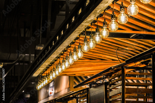 Tungsten circle lamp light on the row, stick on the wood kiosk ceiling. photo