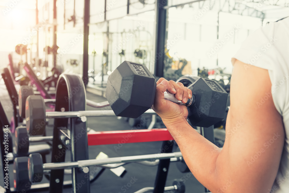 Closeup man guy training in gym with dumbbell. Closeup man guy training in gym with dumbbell.