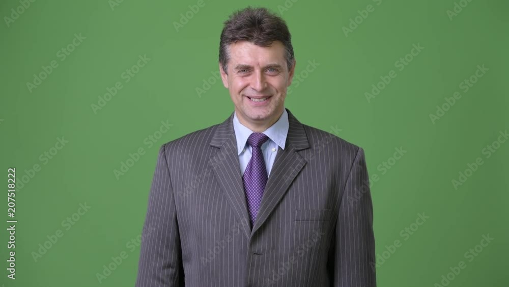 Mature handsome businessman against green background Mature handsome businessman against green background