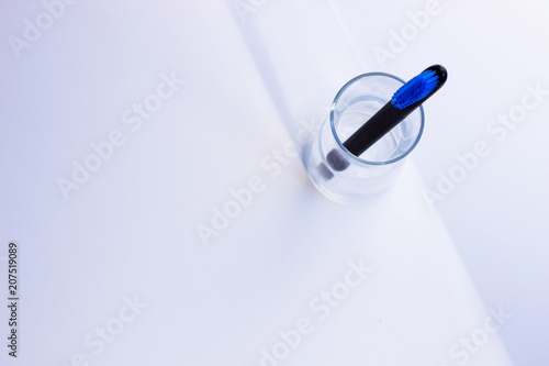 Black style toothbrushes  wiht blue bristle in glass on table on lwhite moning background photo