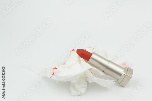 Red lipstick with tissue with red lipstick stain on isolated white background